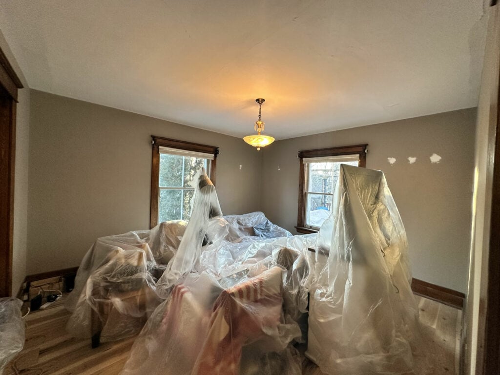 Living room before a new paint renovation, with brown trim and beige walls