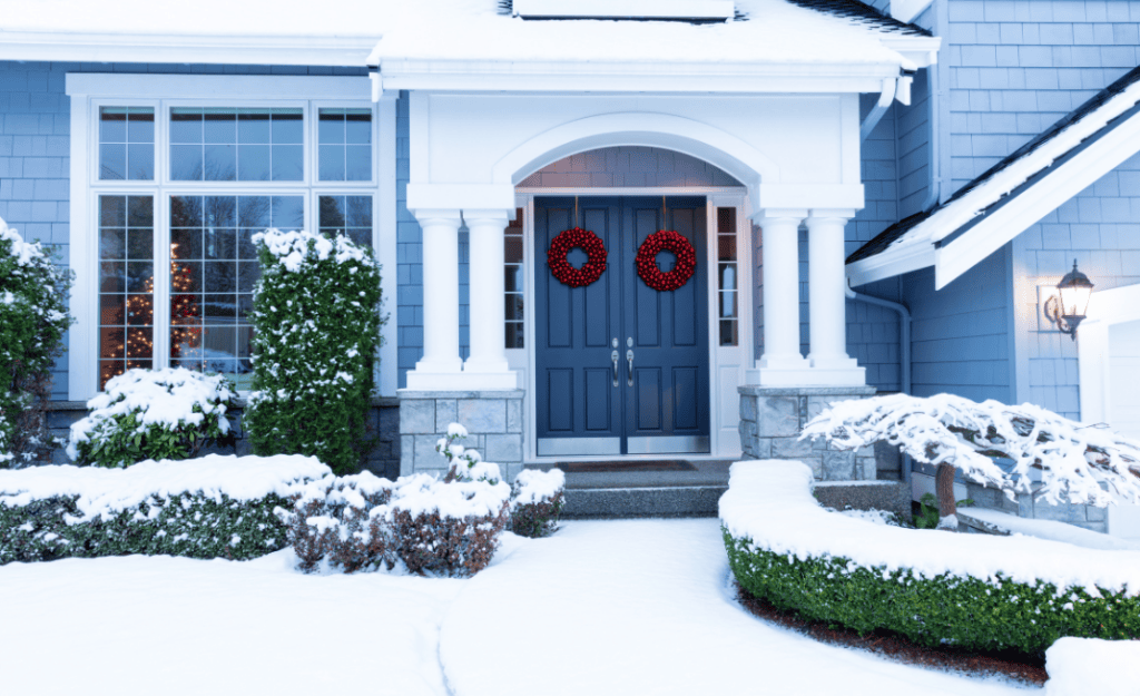 The front exterior of a home freshly painted during the winter with holiday decorations